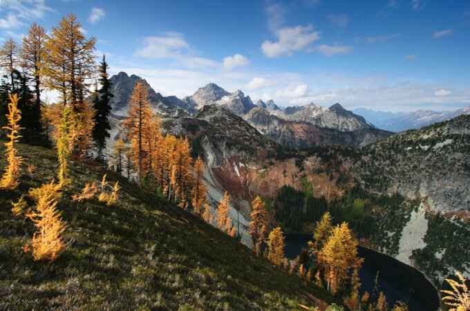 Overlooking a lush green landscape with distant islands from a rocky mountain peak.