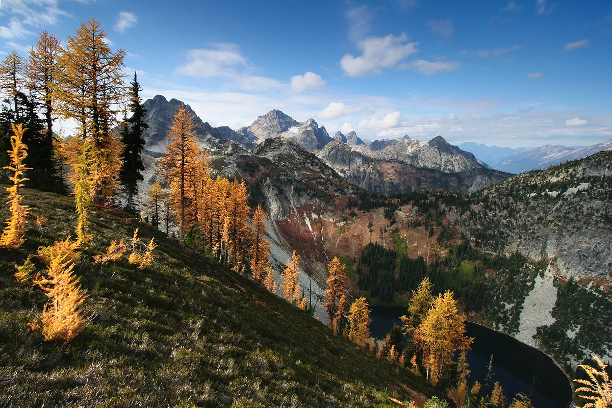 Maple Pass Overlooking a lush green landscape with distant islands from a rocky mountain peak.