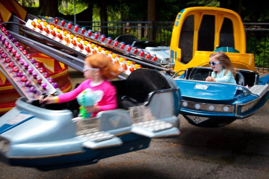 Two children enjoying a ride on a family roller coaster.