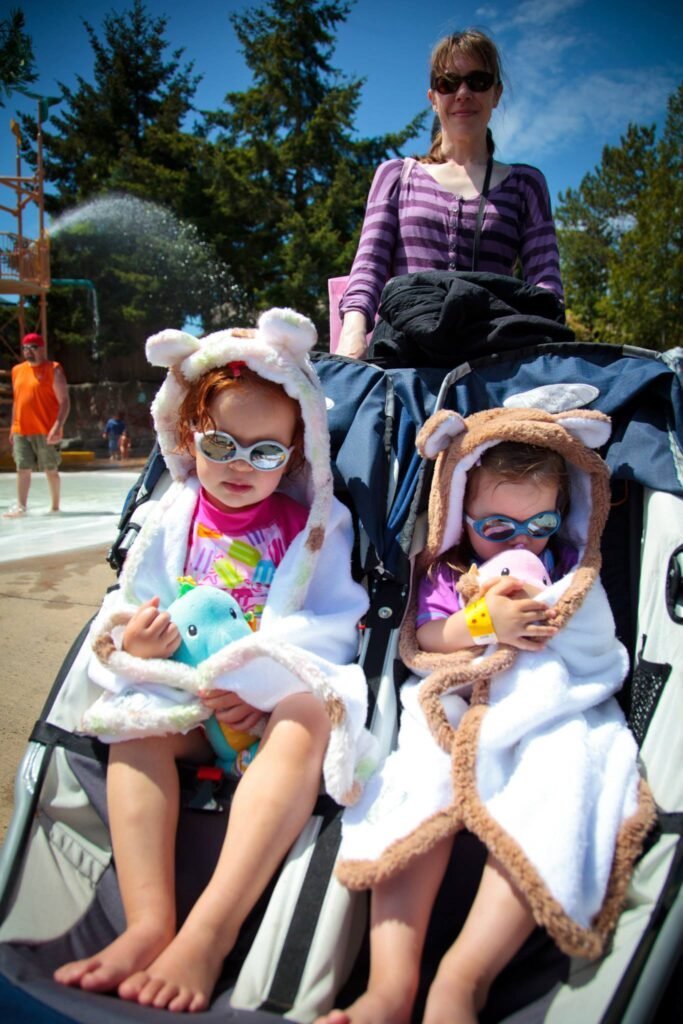 Children enjoy a sunny day at the water park in cozy animal hooded bathrobes.