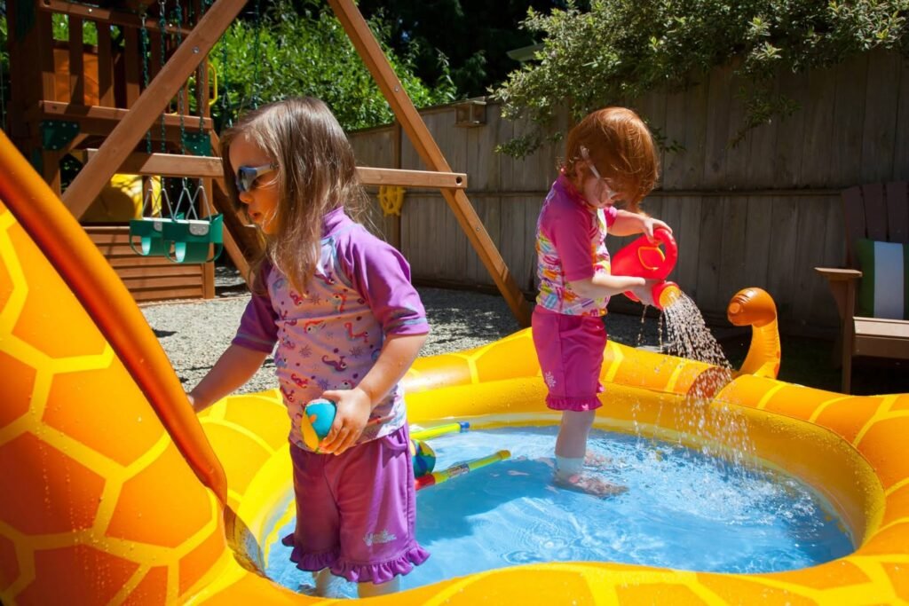 Kids play in a giraffe-themed inflatable pool in the backyard.