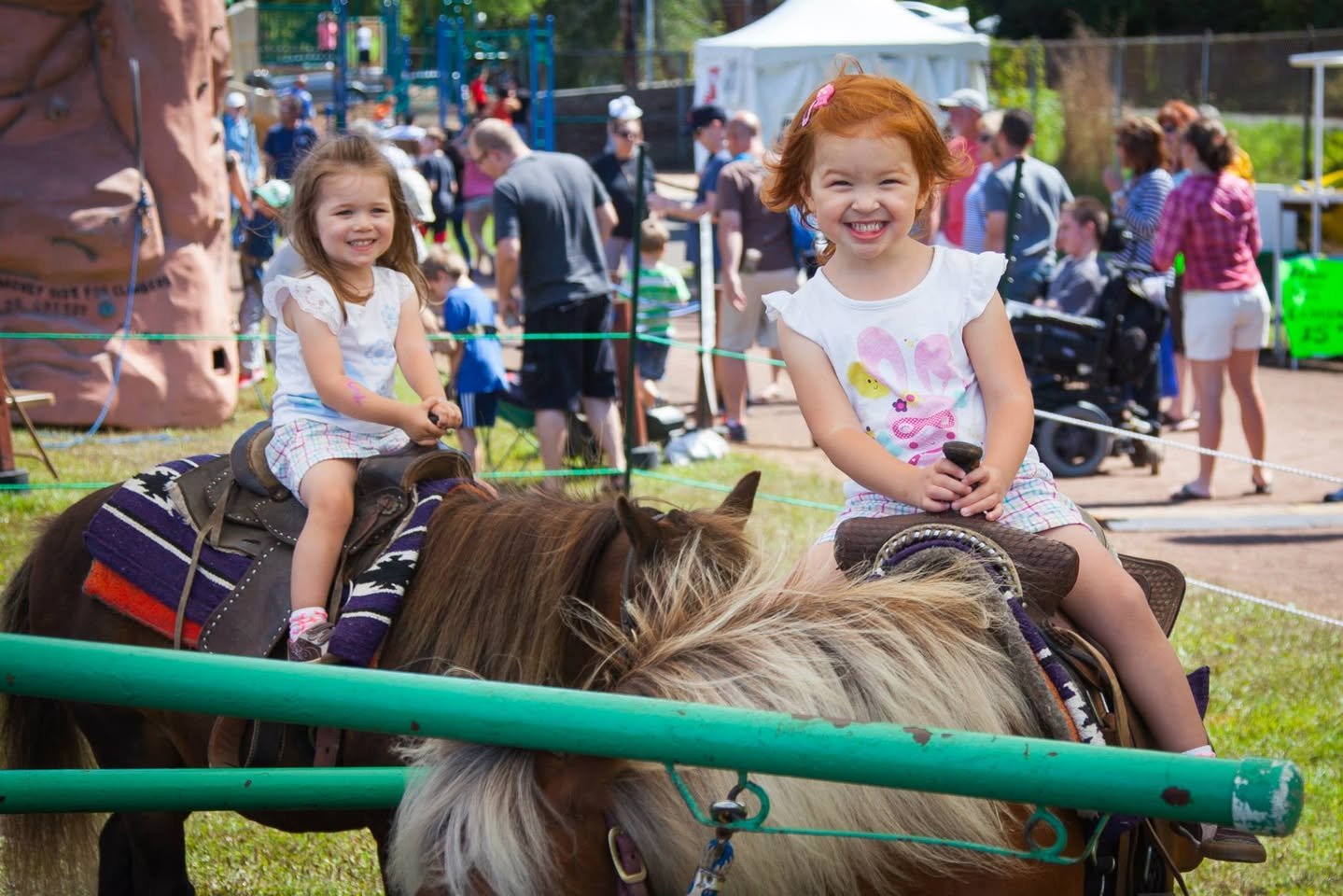 Taste of Edmonds Children enjoying a pony ride at a busy outdoor event.
