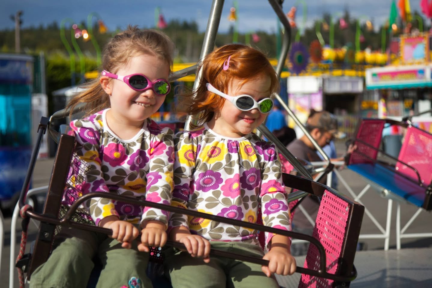 The Evergreen State Fair Children enjoying a Ferris ride wearing colorful 3D glasses and funny glasses at a fair.