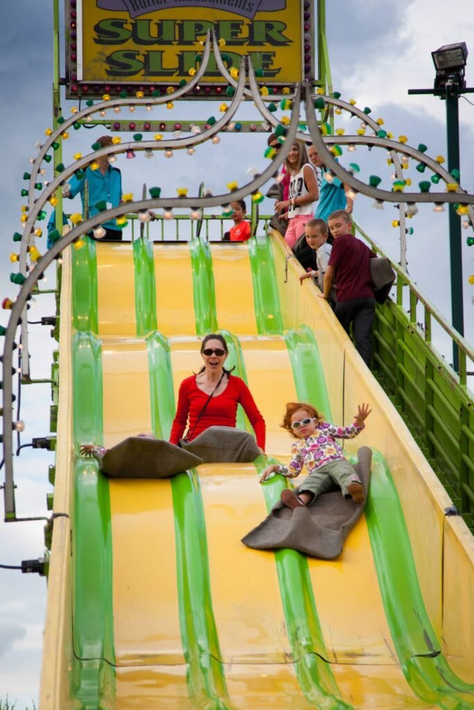People sliding down a giant yellow and green water slide.