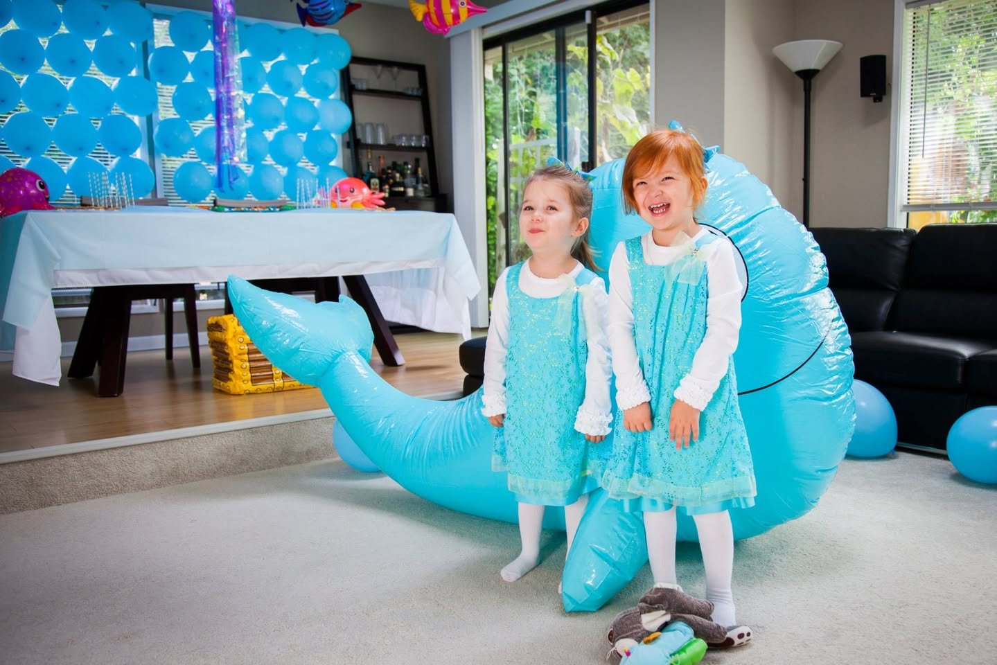 3rd Birthday Children in matching outfits posing with a large blue inflatable whale at a bright indoor celebration.