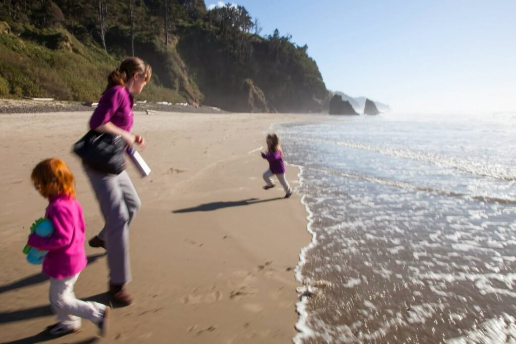 Enjoyable moments at the beach of the Pacific Northwest. Waves crashing on the sand while kids run along the water.