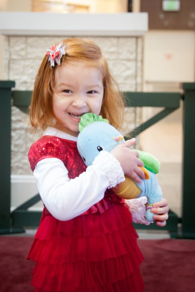 A young child wears a red dress and white hair clip while holding a stuffed turkey. The photo is composed of multiple cropped panels showing the full body and close-up details.