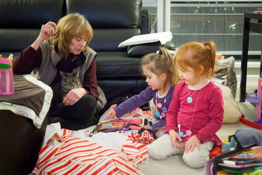 A cozy indoor space where people are engaged in a shared activity, featuring brightly colored items on a striped blanket against a modern backdrop.