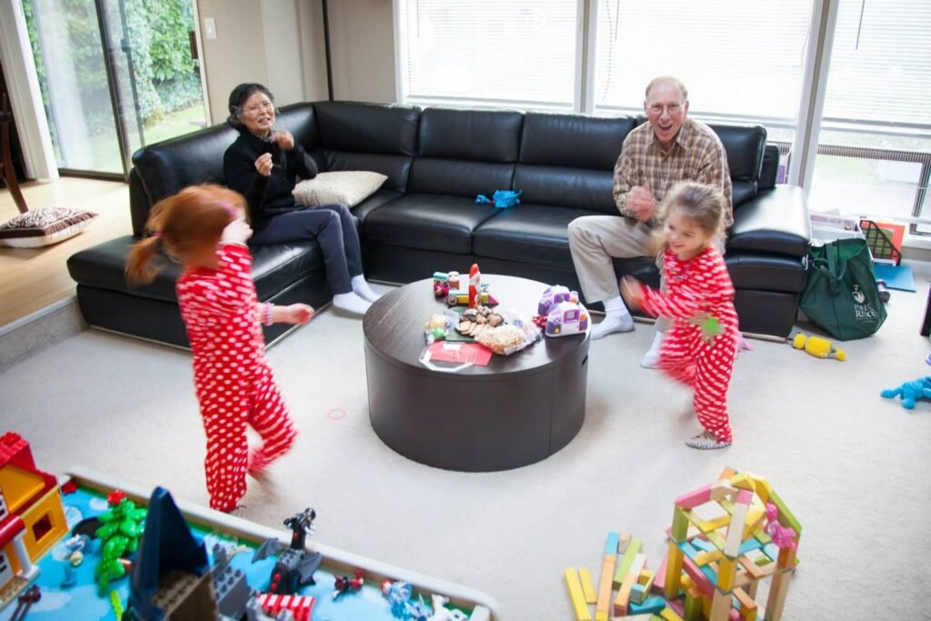 A family enjoys their time together in a modern living room with a black leather sofa and colorful toys.
