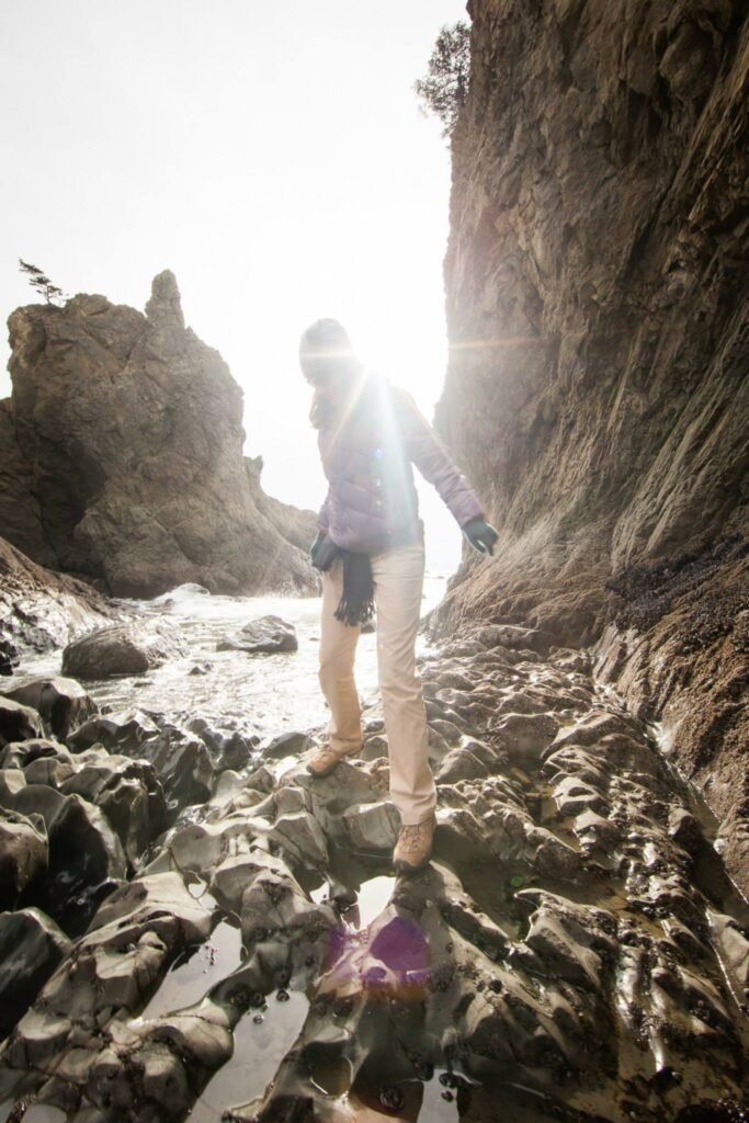 View of a rocky path and cliffside face in bright sunlight.