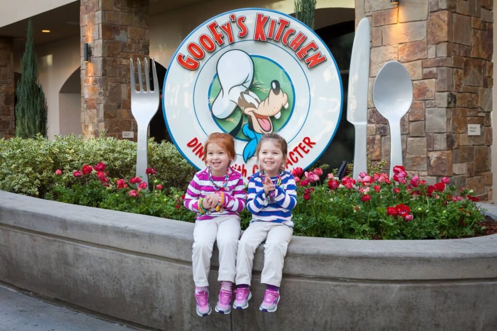 Two children posing in front of the Goofy's Kitchen sign.