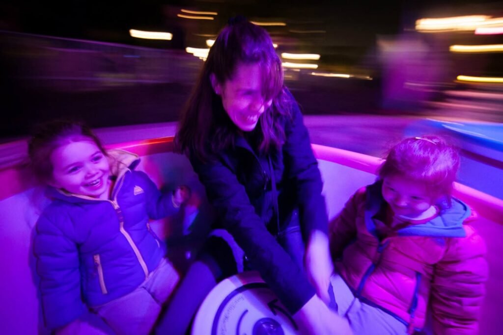 Enjoying a night ride in warm clothing with vibrant purple lighting.