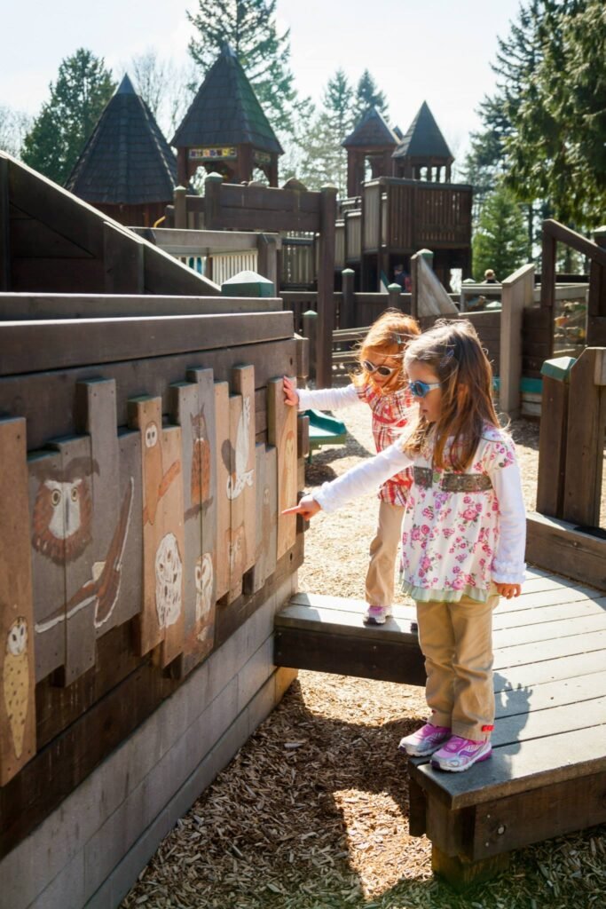Children explore the wooden play structures at a local park.
