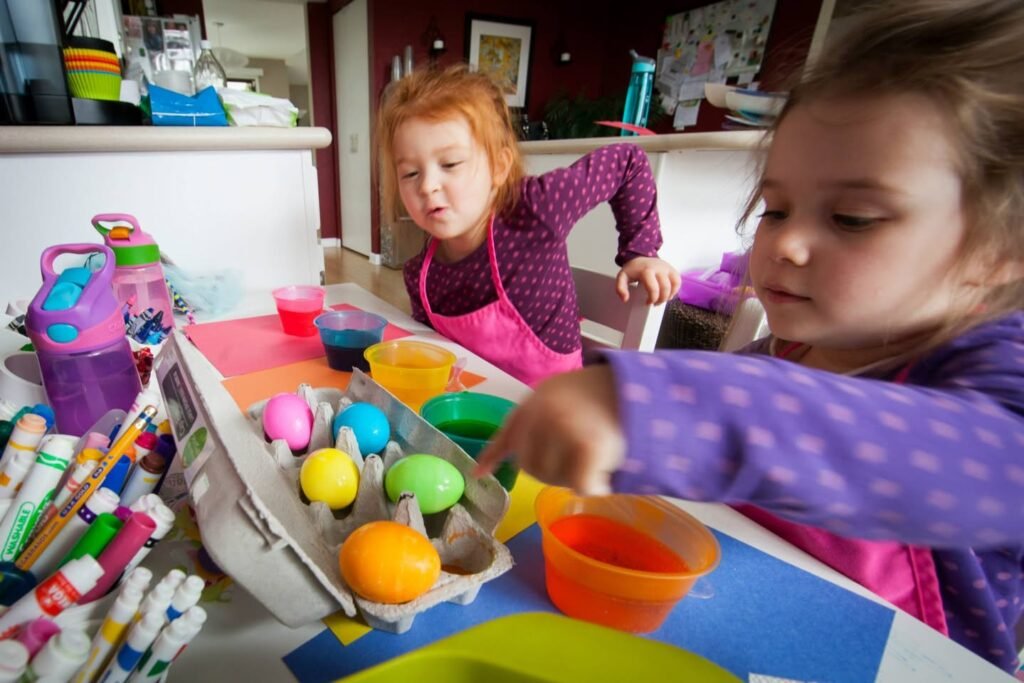 Children paint bright Easter eggs with craft supplies.