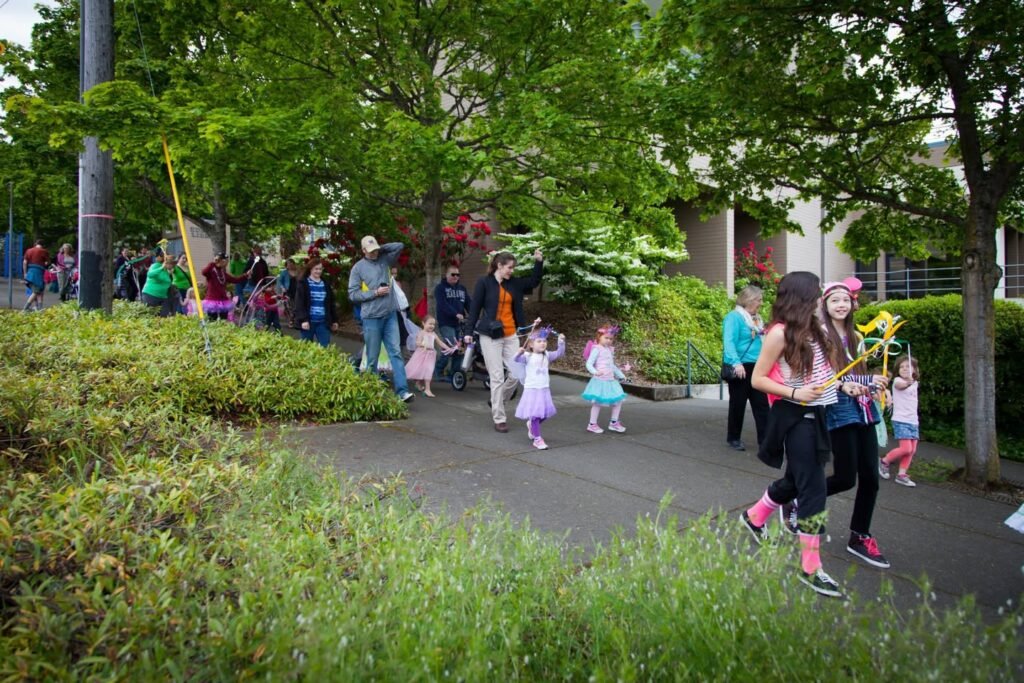 Participants gather on a paved path surrounded by trees at a community event.