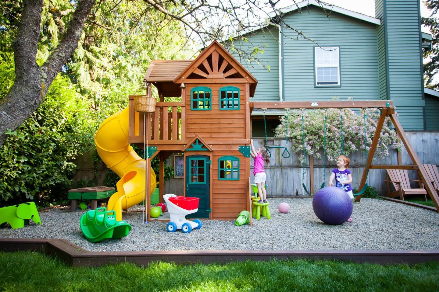 A cozy garden scene featuring a wooden playhouse with a bright yellow slide, colorful toys, and a child playing in a safe, inviting space.