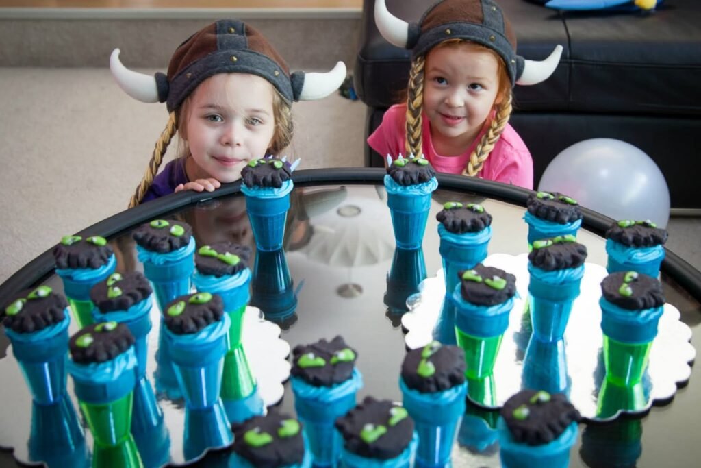 Two children wearing Viking horn headbands look cheerful as they enjoy festive themed cups at a dinner party.