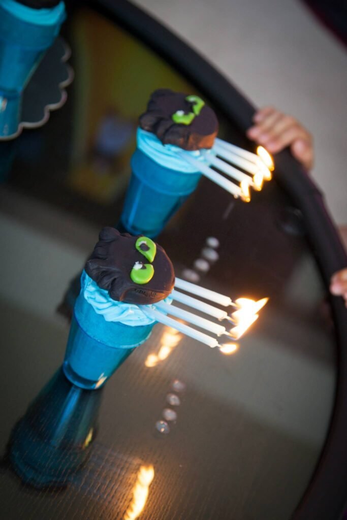 Blue cupcake toppers with hands on a reflective glass table.