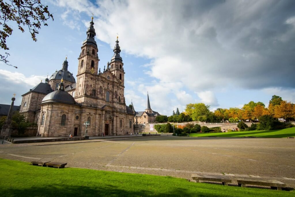 A stunning view of the Cathedral of St. Stephen in Pilsen, Czech Republic, showcasing its grand architecture against a backdrop of a dramatic sky.
