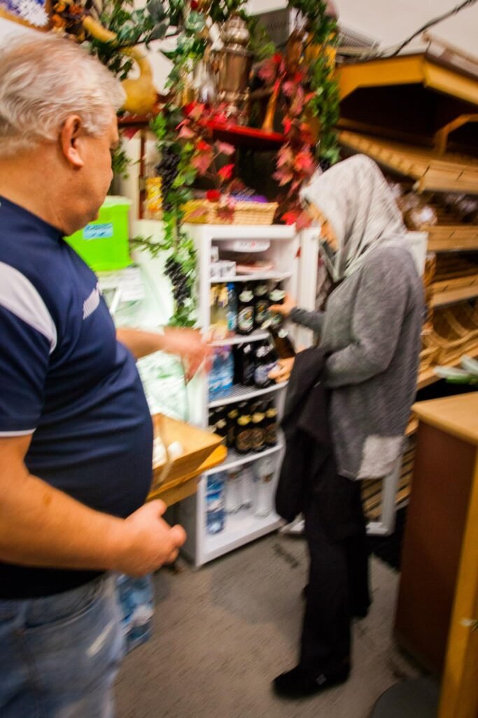 A glimpse into a local market featuring individuals and various goods on display. The scene captures a traditional exchange in a colorful cultural setting.