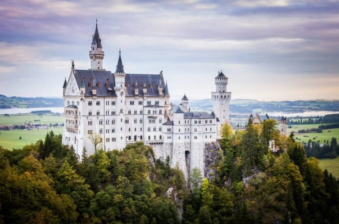 A scenic photo blog post featuring the iconic Neuschwanstein Castle in Germany, showcasing its turrets and surrounding Alpine landscape.