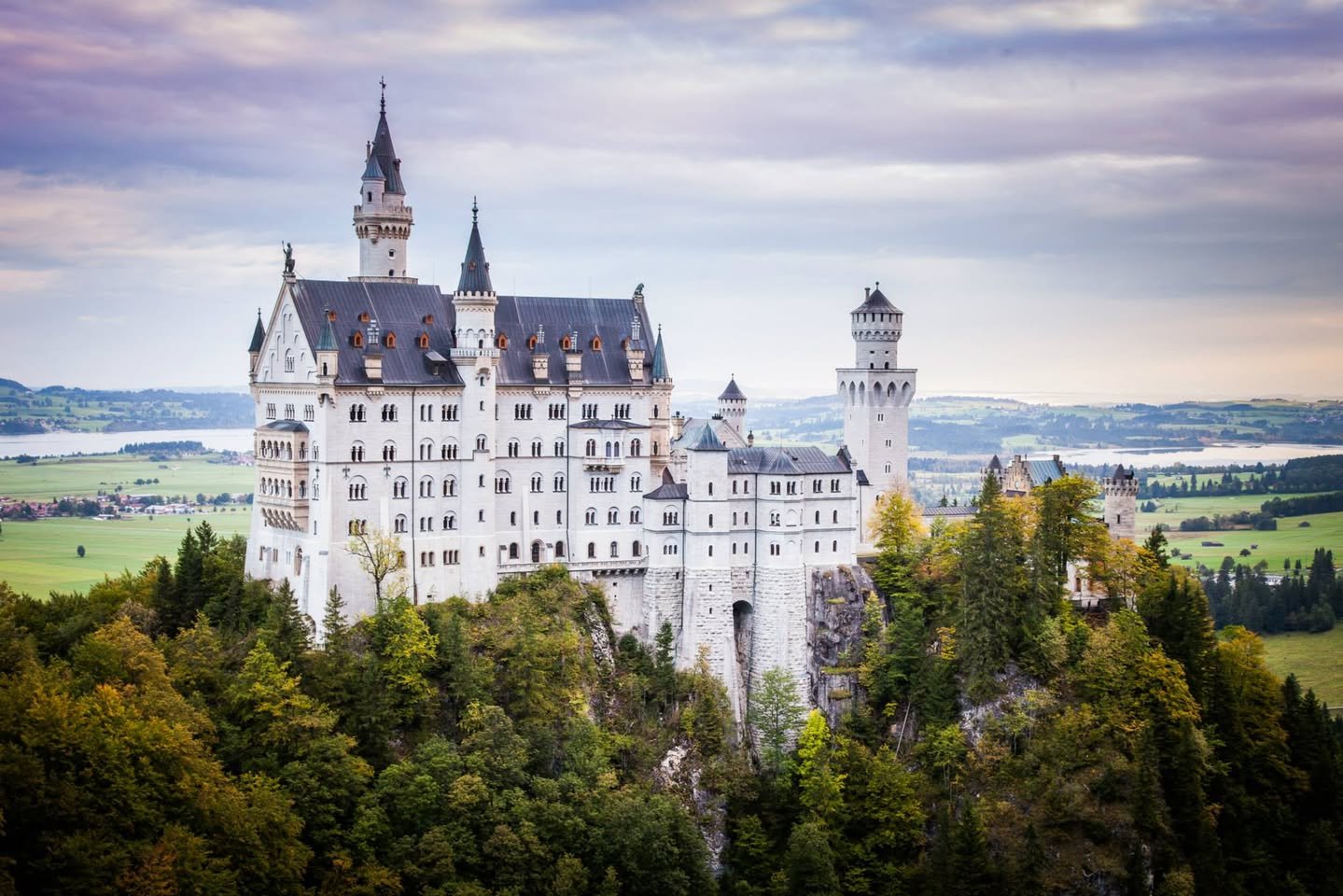 Neuschwanstein Castle & Fussen A scenic photo blog post featuring the iconic Neuschwanstein Castle in Germany, showcasing its turrets and surrounding Alpine landscape.