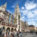 The ornate Gothic architecture of Vienna's City Hall stands under a bright blue sky.