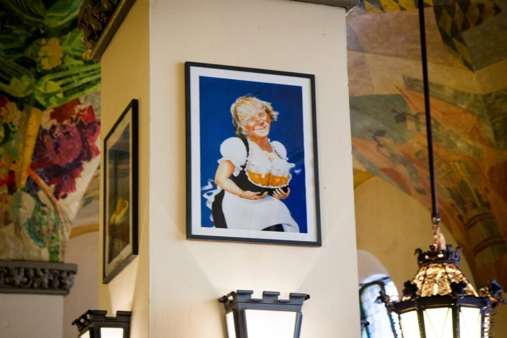 A framed portrait on a yellow wall adorned with a colorful floral mural and lantern lighting.