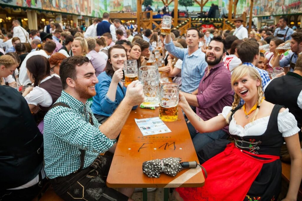 Group of people toasting with beer mugs at an outdoor festival.