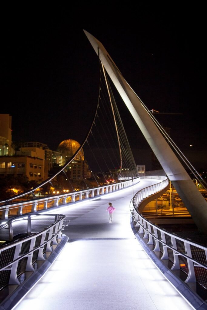 The illuminated pedestrian bridge in Stanley Park under a dark night sky.