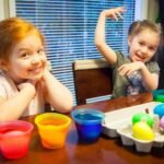 Childrenenjoying a fun bath with dye and colorful eggs.