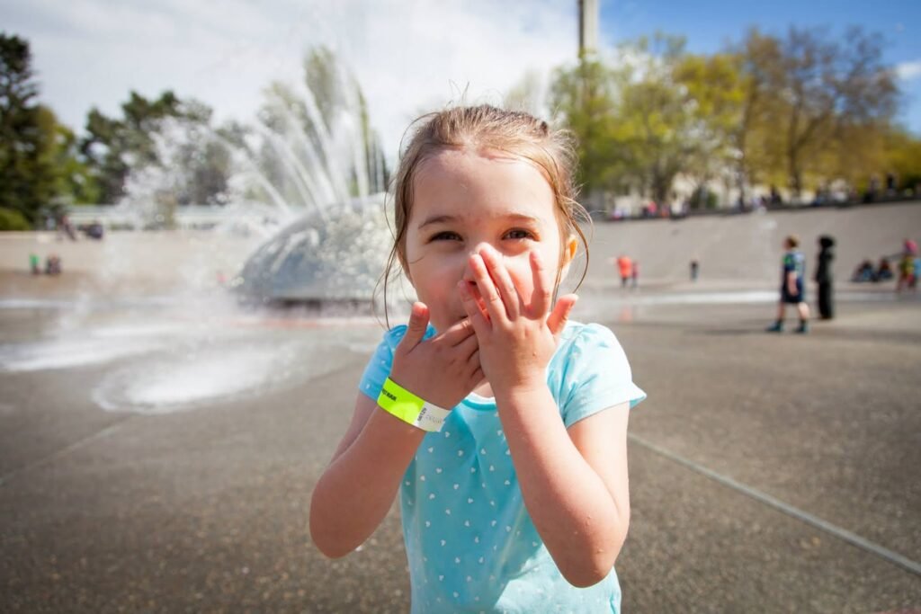 Covering mouth caught up in fountain spray