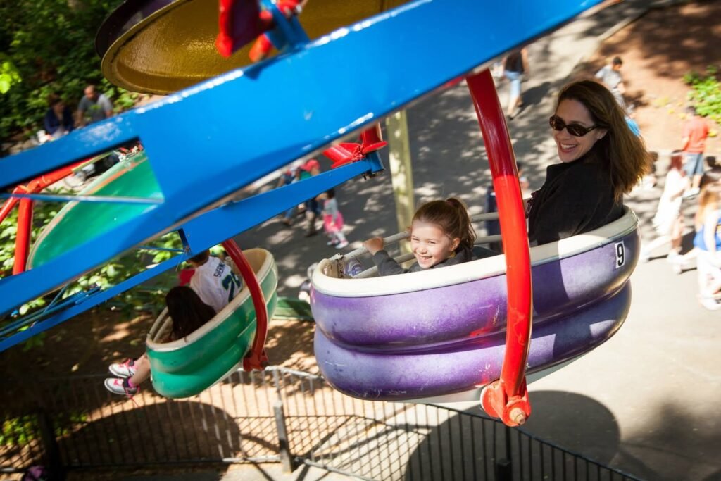 A colorful amusement park ride spins under the sunlight, capturing the joy of a family outing in the Pacific Northwest.