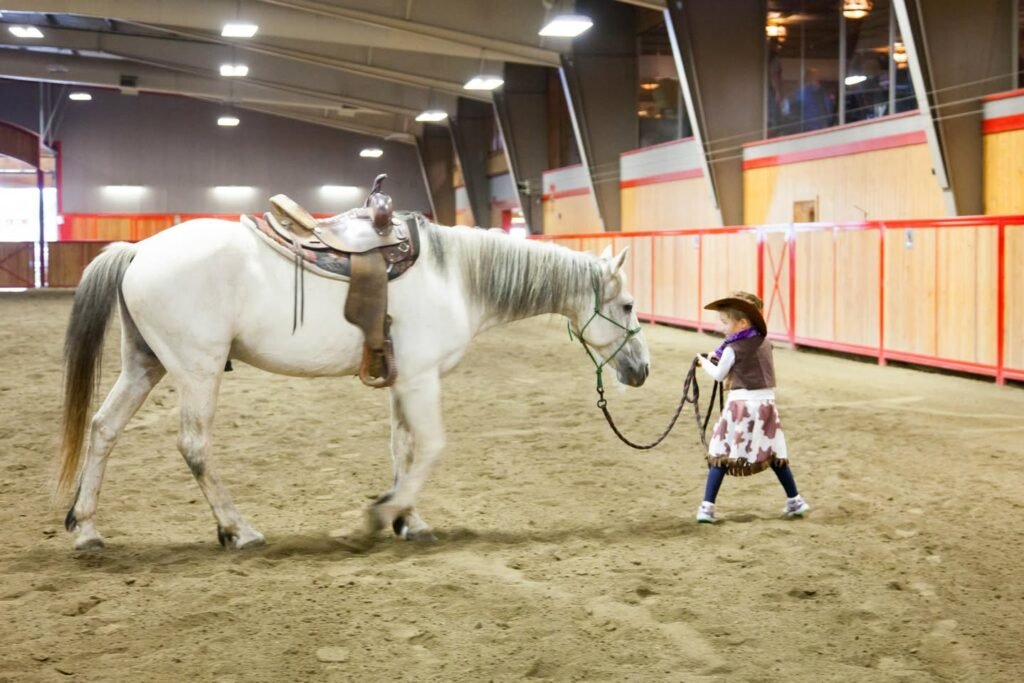 A young teenager practicing basic horse handling in an indoor arena.
