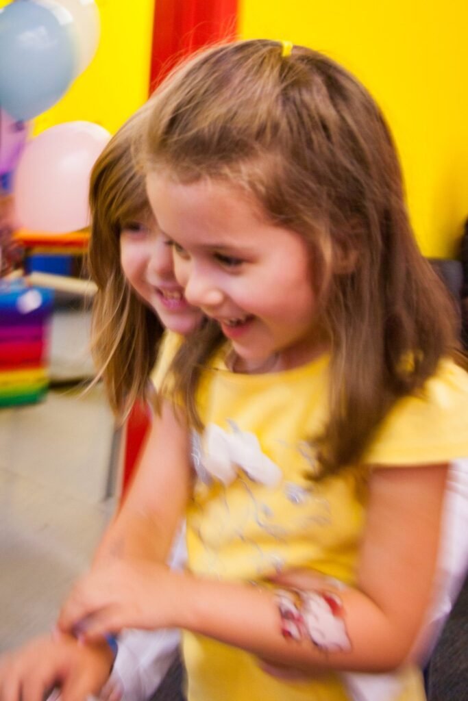 Two children smiling at a colorful party.