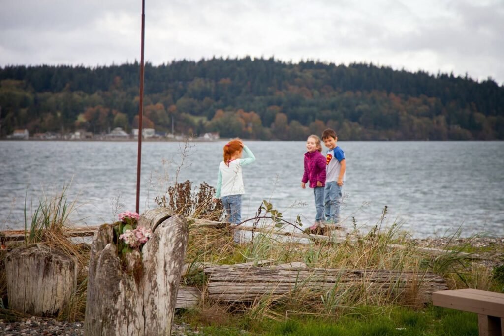 This image captures a family enjoying a rainy day at the lake in the Pacific Northwest, showcasing the natural environment and coastal scenery.