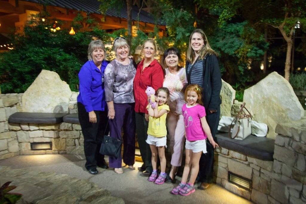 Group photo of a family at a restaurant entrance at night.