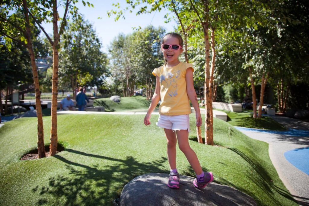 A child playing miniature golf at an outdoor course in the Pacific Northwest.