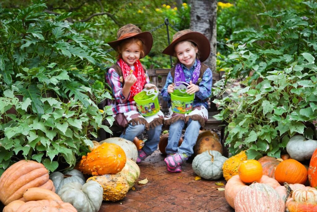 Two children wearing cowboy hats enjoy a day at a pumpkin patch surrounded by colorful gourds and pumpkins.