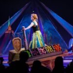 Texan Halloween A performer sings at a glowing night boat in Disney World's Enchanted River, surrounded by vibrant stage lights and colorful baskets of fruit.