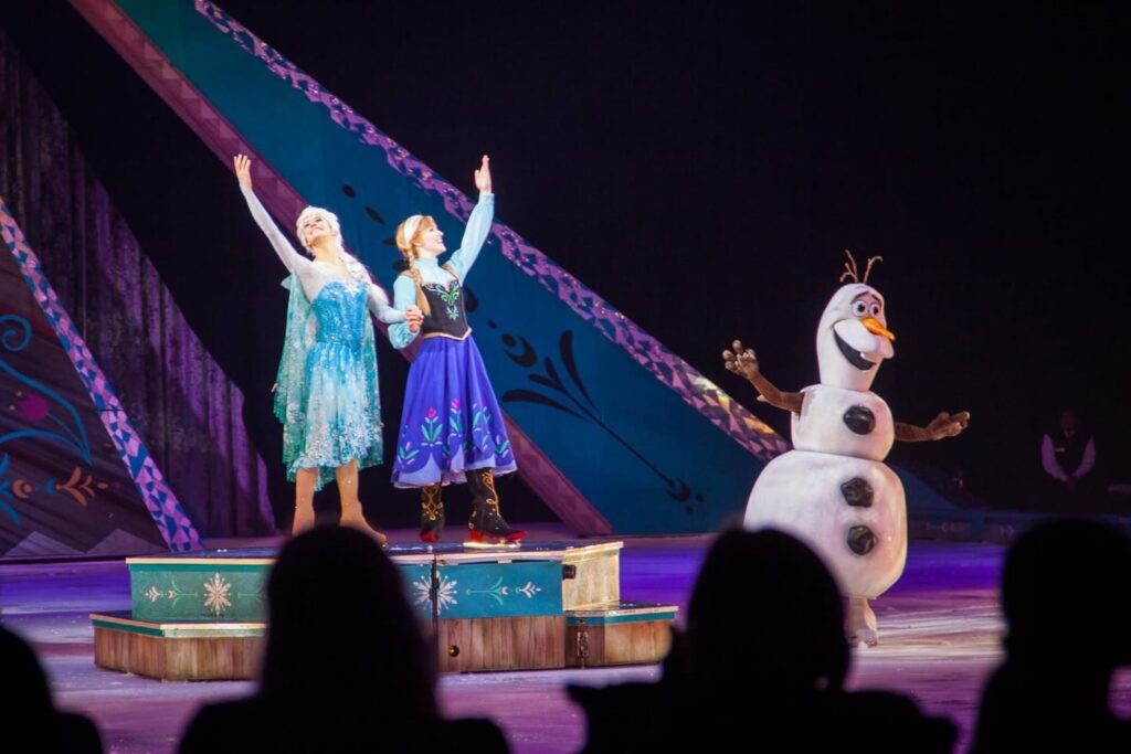 A scene from the Frozen On Ice show featuring characters on stage and a snowman puppet.