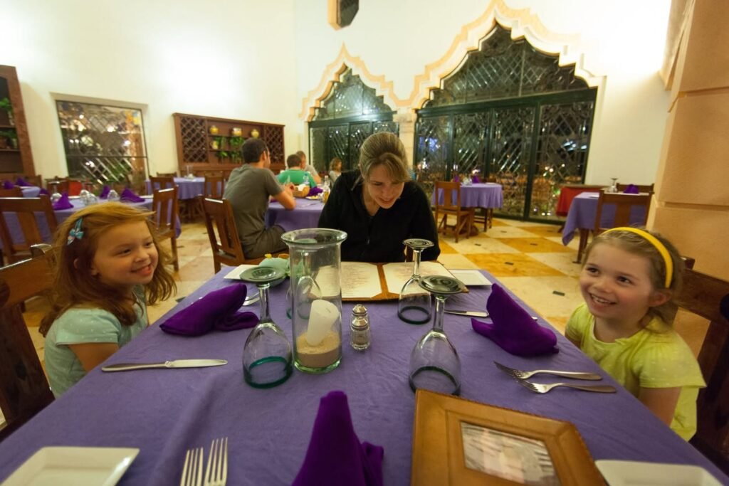 Family enjoying a meal at a restaurant with distinctive architecture in Marrakech, Morocco.