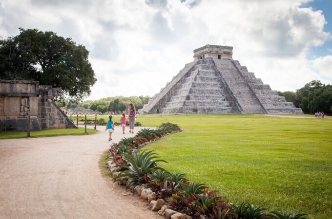 Staircase and vast lawn at Chichen Itza. Classic shots of El Castillo under a cloudy sky.