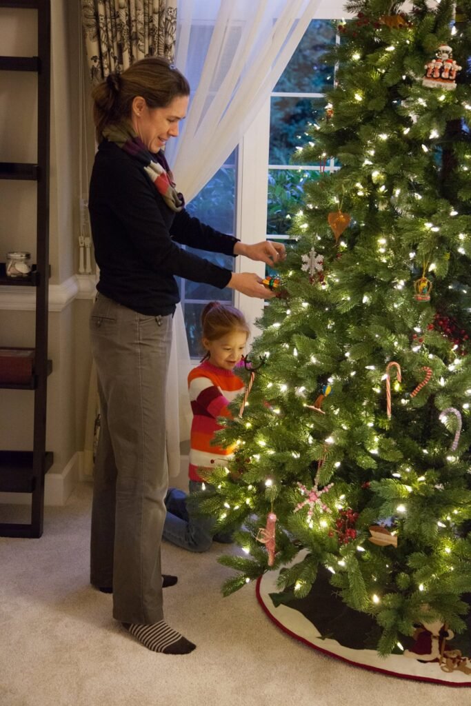 Family decorating a Christmas tree at home