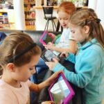 Children engaged with tablets in a store.