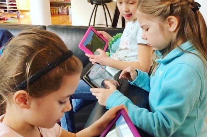 Children engaged with tablets in a store.