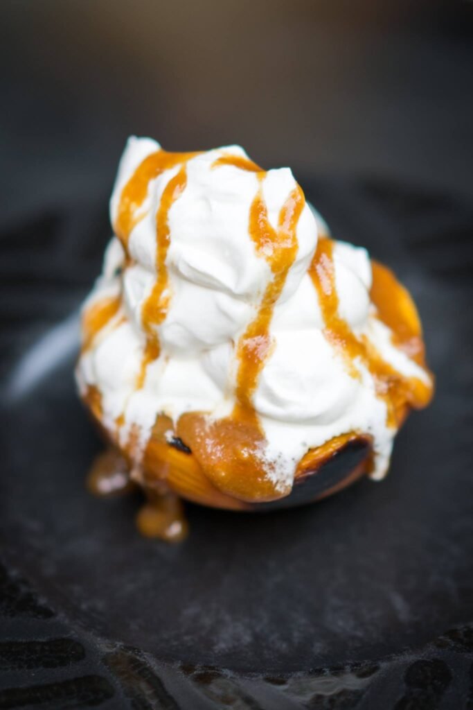 Close-up of a coffee drink topped with whipped cream and a caramel drizzle.
