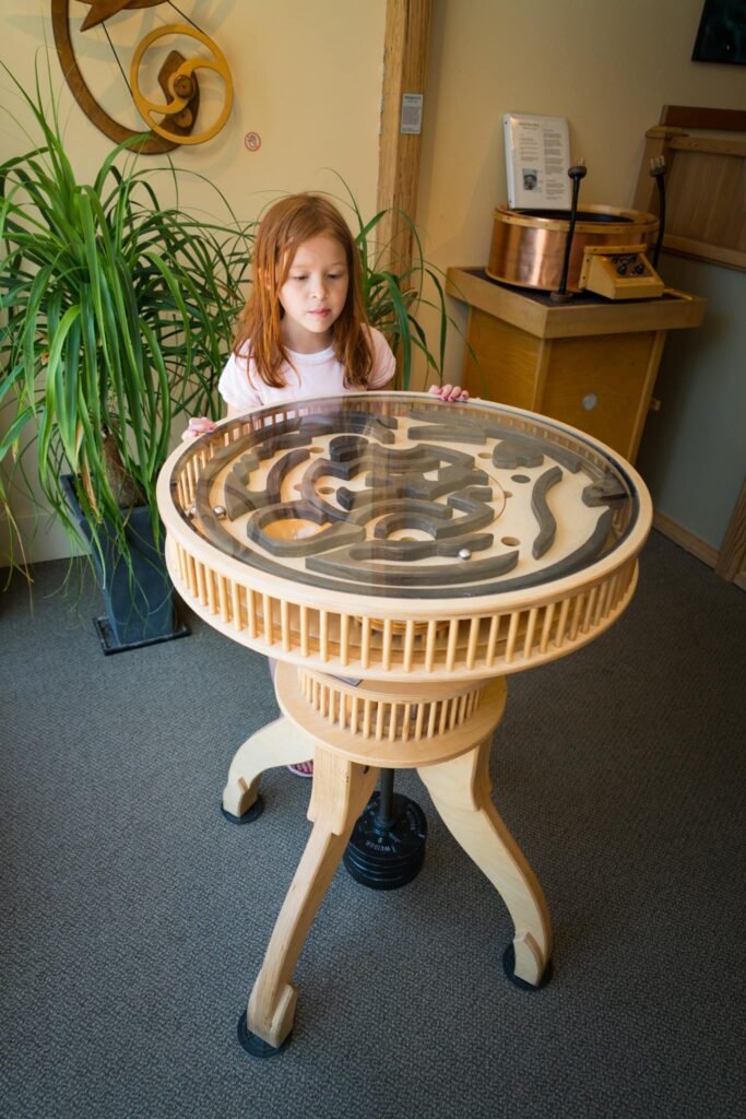 A child learns about snakes in an indoor exhibit at the zoo. The interactive station features several live snakes in a secure, wheel-like display.