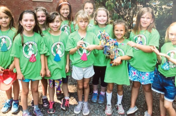 Children wearing green t-shirts with logo