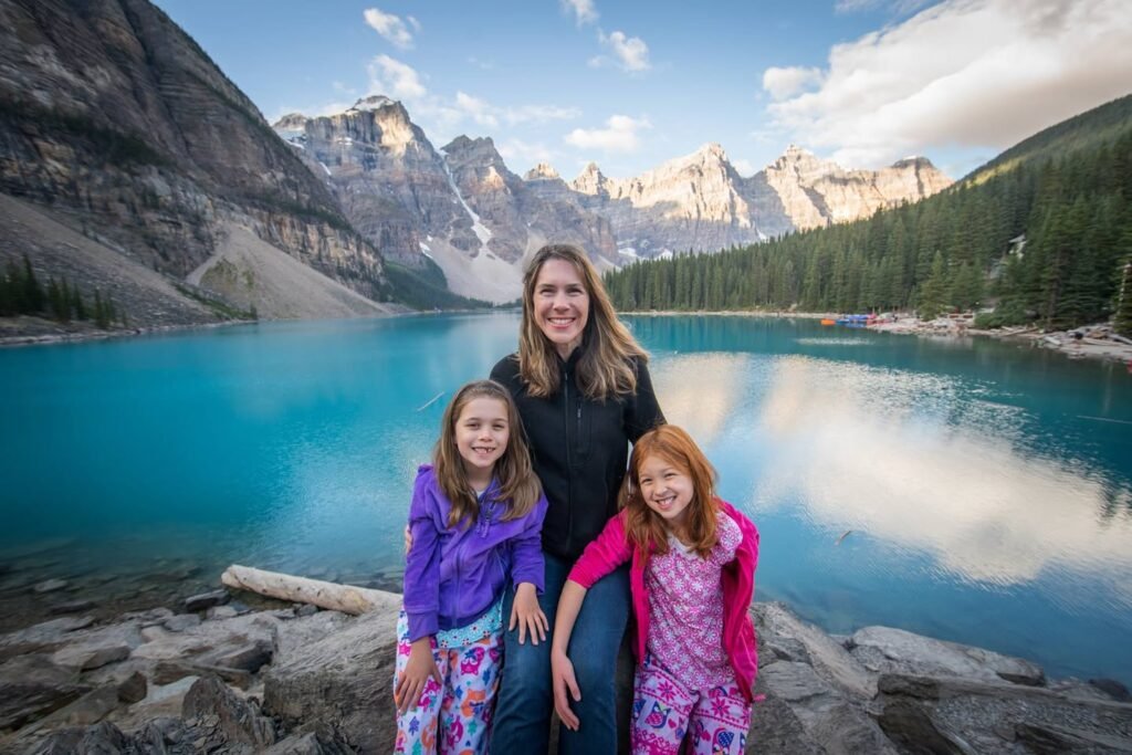 A group photo by the stunning turquoise waters of Lake Louise. Mountain scenery provides a breathtaking backdrop.